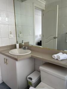 um banheiro com uma pia, um espelho e um vaso sanitário em Suite amoblada con aparcamiento privado excelente vista y ubicación! Sector La Carolina em Quito