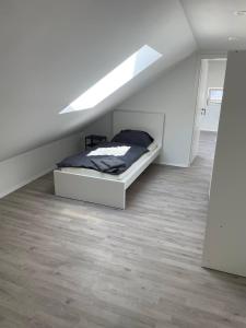 a white bedroom with a bed in a attic at Geräumige Ferienwohnung Eschelbronn in Eschelbronn +2 photos