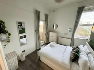 a bedroom with a white bed and a window at Spacious modern 1-bed apartment near Victoria Park & London Stadium in London