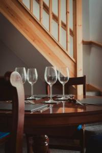vier Weingläser auf einem Holztisch in der Unterkunft Charming 2 Bedroom Cottage mid town on quiet road in Sudbury