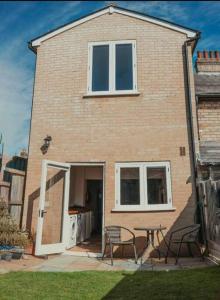 ein Haus mit einem Tisch und Stühlen davor in der Unterkunft Charming 2 Bedroom Cottage mid town on quiet road in Sudbury