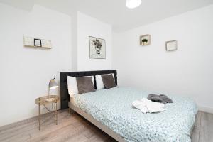 a bedroom with a bed with a blue comforter at Large 4 bedroom house with parking available in Golders Green
