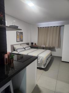 a bedroom with a bed and a table in it at Studio Wets Fit - 2 in Mossoró