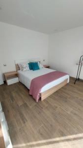 a bed in a bedroom with a wooden floor at Refúgio D'Aldeia in Leiria +33 photos