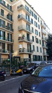 un grand bâtiment avec des voitures garées devant lui dans l'établissement Palma Residence, à Rome