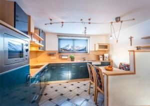 a kitchen with green cabinets and a table with chairs at Haus Michael in Tux