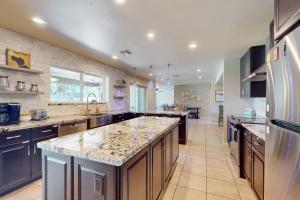 a large kitchen with a large center island with granite counter tops at Geneva Drive Retreat in Tempe
