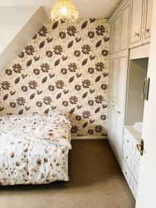 a bedroom with a bed with a floral wallpaper at Piccadilly Rooms near City Centre in Birmingham
