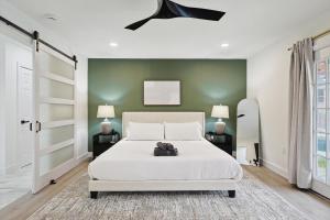 a bedroom with a white bed and a green wall at 3-BD Backyard Oasis w Pool Patio Firepit in Irving
