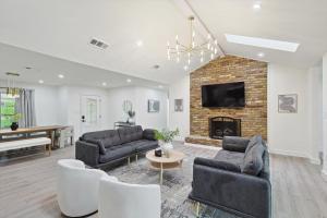 a living room with two couches and a fireplace at 3-BD Backyard Oasis w Pool Patio Firepit in Irving +42 photos