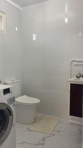 ein weißes Badezimmer mit einer Waschmaschine und einem Waschbecken in der Unterkunft Luxa House Staycation Tagaytay in Panungyanan