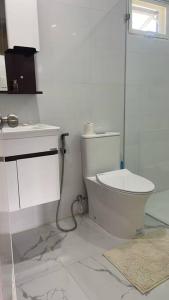 ein weißes Badezimmer mit Toilette und Waschbecken in der Unterkunft Luxa House Staycation Tagaytay in Panungyanan