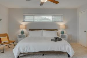 a bedroom with a large white bed with a ceiling fan at Dream Vacation Home with Pool for Large Groups in Garland