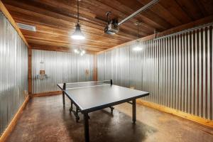 a ping pong table in a room with wooden ceilings at Your Rustic Retreat w Backyard Oasis Pool Patio in Keller