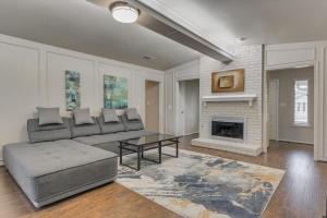 a living room with a couch and a fireplace at Spacious and Modern Home with Private Pool in Plano