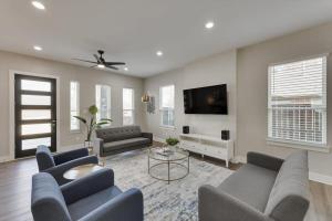 ein Wohnzimmer mit Sofas und einem Flachbildfernseher in der Unterkunft Modern and Spacious High End Home near Downtown in Dallas