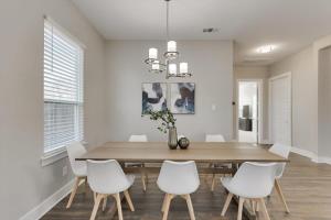 ein Esszimmer mit einem Holztisch und weißen Stühlen in der Unterkunft Modern and Spacious High End Home near Downtown in Dallas