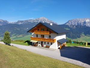 een groot wit huis met bergen op de achtergrond bij Maierlhof in Aich