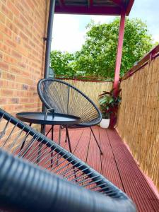 ein Stuhl auf einem Deck mit einer Ziegelmauer in der Unterkunft Beautiful 2-Bed City Centre Apartment with Balcony in Milton Keynes