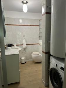 une salle de bain avec un lavabo et une machine à laver dans l'établissement Appartement , piscine aux portes de Monaco, à Cap d'Ail 29 autres photos