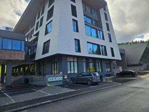 a car parked in a parking lot in front of a building at Mountain goat Bjelašnica in Bjelašnica