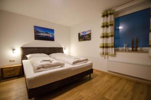 una camera da letto con un letto e una grande finestra di Appartement THE GOOD VIEW by All in One Apartments a Zell am See