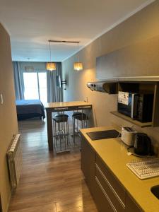 a kitchen and living room with a bed in a room at Departamentos Casa de playa in Necochea