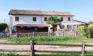 a house behind a wooden fence in front of a house at La vigna in Costigliole dʼAsti