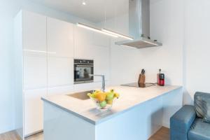 a kitchen with a sink and a bowl of fruit on a counter at Apartman Dino in Split