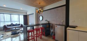 a kitchen with red bar stools and a living room at ARTEplus JALAN AMPANG, KLCC in Kuala Lumpur