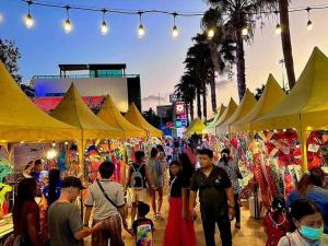a crowd of people walking through a market with yellow umbrellas at Beautiful Jomtien oceanview 34sqm 28 floor 1bedroom วิวทะเล in Jomtien Beach +127 photos