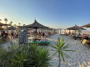 a group of people sitting on a beach with umbrellas at Kilians apartment 1 in Grao de Castellón