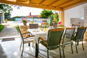 a dining table and chairs on a patio at House Ladonja with private pool in Bale