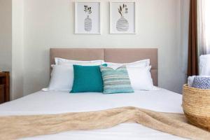 Una cama con almohadas azules y blancas. en New Central Studio - Super Sea View n' easy Access, en Himare