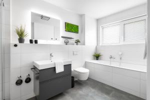 a white bathroom with a sink and a toilet at Nordseeoase in Büsum +29 photos
