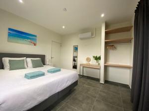 een slaapkamer met een groot wit bed en een bureau bij Villa Cabana Mambo Beach in Willemstad +21 foto's