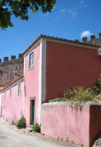 un edificio rosa sul lato di una strada di Casa da Cerca a Óbidos