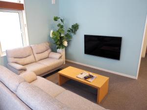 a living room with a couch and a coffee table at Choine Hotel Sapporo Teine - Vacation STAY 97420v in Sapporo