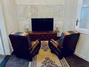 a living room with two chairs and a table with a tv at Csaky palace 2 Bratislava in Bratislava