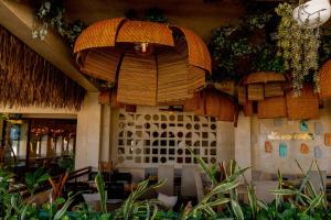 a restaurant with tables and umbrellas and plants at Hotel Scappata in Progreso