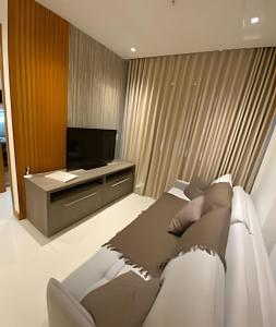 a living room with a couch and a television at Flat hotel 909 RioCentro / Rock inRio / Projac /Farmasi Arena / Barra da Tijuca / rRio de Janeiro in Rio de Janeiro