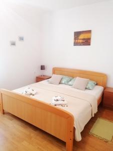 een slaapkamer met een groot bed met witte lakens bij Apartman Volarevic in Donji Karin