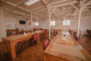 a large room with long wooden tables and chairs at Hostal Tierra Amarilla in Tierra Amarilla