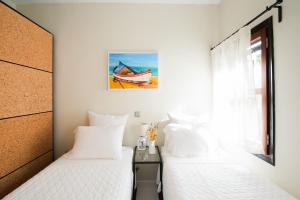 a bedroom with two beds and a window at Kavos House in Meyisti