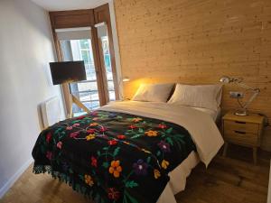 a bedroom with a large bed with a floral blanket at Apartamento de Montaña en Baqueira con Parking y Totalmente Equipado in Betrén