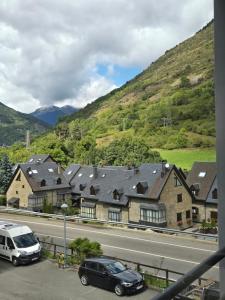 a building with cars parked on the side of a road at Apartamento de Montaña en Baqueira con Parking y Totalmente Equipado in Betrén