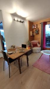 a living room with a wooden table and a couch at Petit cocon proche Saint Gervais in Saint-Gervais-les-Bains