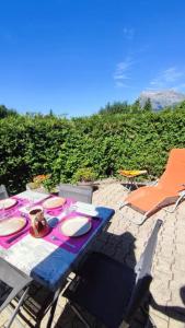 a picnic table with plates and chairs on a patio at Petit cocon proche Saint Gervais in Saint-Gervais-les-Bains
