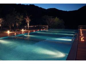 a large swimming pool at night with lights at Olive Bay Hotel - Vacation STAY 91402v in Saikai