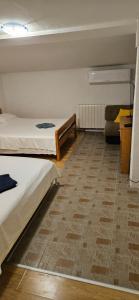 Pokój z 2 łóżkami i kanapą w obiekcie Apartments Hugo w mieście Malinska